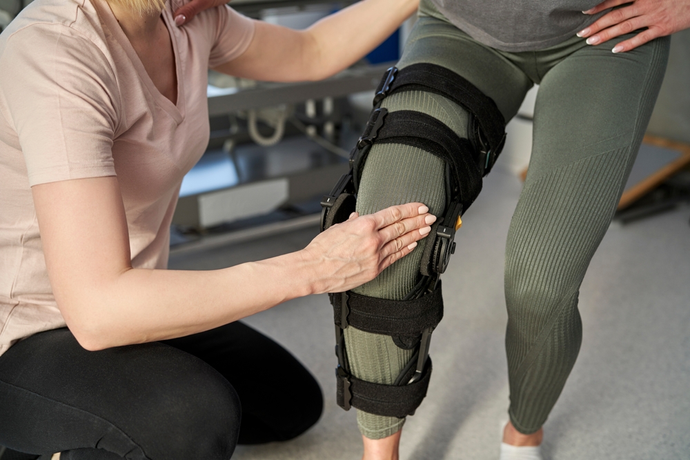 Caucasian woman with orthosis working with physical therapist